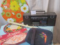 Set overview showing patio table, boom box, computer bag, Chinese checkers tin and Scrabble game.