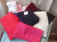 Overall view of assorted fabric pieces including fleece, stretch terry, stretch velour, and novelty taffeta in various colors