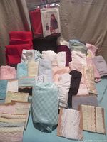 Overview of various folded fabric pieces including lingerie knits in pastel colors and lace trims grouped on a surface.