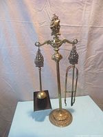 Full set assembled on stand showing tongs, shovel, poker hanging, with ship figure on stand top