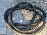 Full coiled hose on rough concrete surface demonstrating length and condition