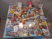 Photo showing a large spread of various travel and souvenir fridge magnets on a light blue surface including unique shapes and designs representing places from around the world.