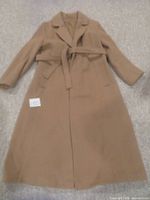 Full front view of the long camel-colored wool and camel hair blend wrap coat laid flat showing the style, length, and belt detail.