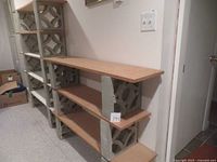 Side view of one shelving unit showing wooden boards supported by concrete blocks stacked in a vertical column.