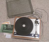 Top-down view of Thorens TD 145 turntable on carpet with instruction manual, receipt and lot number card 201.