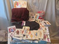 Overall lot of sewing patterns, vintage buttons, and fabric including fleece and silk pieces