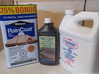 Three wood preservative products: Wolman RainCoat clear water repellent in a 4.73 liter metal can, Copper II Green Preservative in a black bottle, and Zinc Naphthenate in a white jug.
