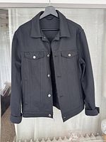 Front view of the black men’s Zara jacket showing button closures, collar, chest pockets, and sleeves.