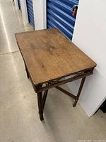Front angle of vintage wood console table showing rectangular top and lattice apron design.