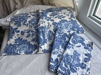 Blue floral placemats and matching napkins folded on a table.