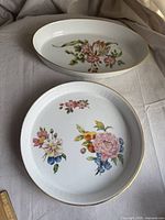 Oval dish with colorful floral pattern and gold rim on cream background