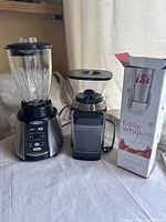 Photo showing entire lot with blender, coffee grinder and boxed iSi Easy Whip Plus