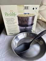 Freshlife model 2000 sprouter machine in box with the fry pan and black plastic spoon on white surface