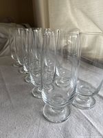 Ten clear crystal footed glasses arranged in a line, showing their uniform shape and height.
