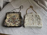 Two vintage ladies' purses side by side. Left purse with tapestry floral fabric and metal frame, right purse white and beaded with gold chain.