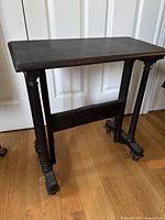 Front view of vintage wooden small side table with rectangular top and detailed turned legs.