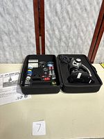 Full kit including the microscope on right and an accessory case with slides, tools, and other components on left, along with a printed manual.