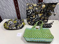 Three quilted bags and one wallet arranged on a surface, featuring various fabric patterns and colors.