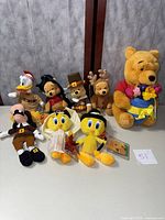 Full group of 8 stuffed animals including Tweety Birds, Winnie the Pooh, Goofy and Donald Duck in various costumes.