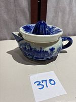 Side view of Victoria Ware Flow Blue ironstone citrus juicer showing the handle, spout, and blue scenic pattern.