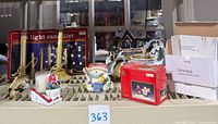 Overview photo of all lot items including candolier, candles, Christmas house scene, candle holders, and ornaments