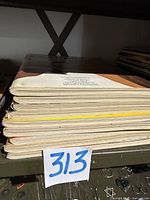 Stacked side view of nine vintage Playboy magazines showing thickness and condition of covers and pages.