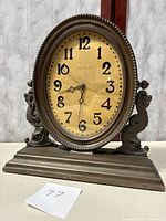 Full frontal view of the Waltham brass mantel clock showing oval face and base.