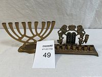 Two vintage brass Hanukkah menorahs side by side, showing the modern abstract design on the left and the traditional Lions of Judah design on the right.