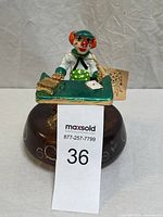 Full front view of handmade clown music box figurine showing desk, clown, and painted wood dark brown base with colorful decorations.