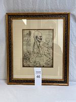 Frontal photo of the framed Leonardo da Vinci anatomical study print showing the detailed sketch of human skull and figures with handwritten notes. Gold patterned frame, double matted with cream and black and gold mats.