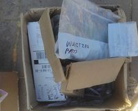 Open box showing several labeled plastic bags with parts including Wurlitzer components.