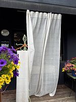 Sheer curtain panel hanging, showing fabric texture and length.