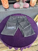 Front view of black Levi's 501 jeans laid flat showing front pockets, fly, and leg details.