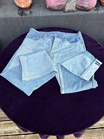 Light blue two-tone Levi's 501 jeans laid flat with legs folded, showing overall color and fabric.