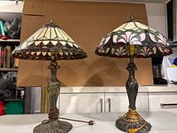 Front view of both lamps on tabletop against cardboard backdrop