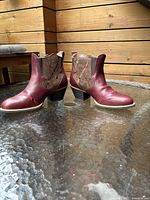 Side profile shot of the women's cowboy boots showing red leather toe and heel and brown leather shaft with decorative stitching.