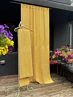 Curtain panels hanging outside, showing full length and texture in natural light.