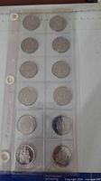 Front view of plastic sleeve holding 12 Canadian 50¢ coins
