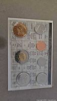 Front of sealed coin set showing six coins and specification chart