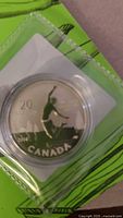 Oblique view of the 2014 $20 Canadian fine silver coin in capsule within green card packaging