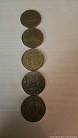 Stack of five Canadian dollar coins showing reverse designs