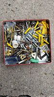 Open red tin showing assorted screws, anchors, brackets, couplers
