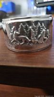 Front view of GERO silverplate napkin ring showing embossed deer and trees