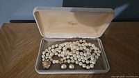 Necklace and earrings arranged in open presentation box
