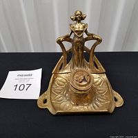 Full view of brass figural inkwell with lot number card
