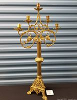 Full view of brass candelabra showing five arms and triangular base