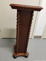 Full side view of oak pedestal showing carved twist edges and base