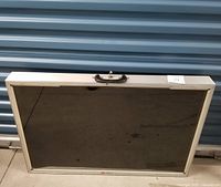 Front view of closed aluminum jewelry display case with glass front and handle