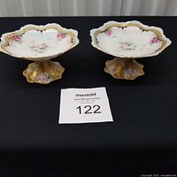 Pair of hand painted pedestal compotes on black background