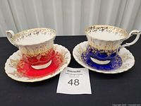 Front view of both cup and saucer sets showing colors and gold overlay